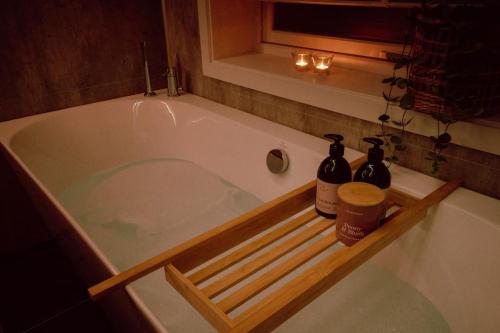 a bath tub with two bottles and a window at Reine Front View - Mountain & Seaview in Reine