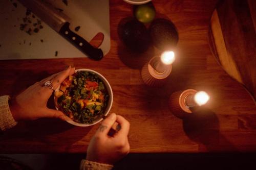 a person holding a bowl of food on a table at Reine Front View - Mountain & Seaview in Reine