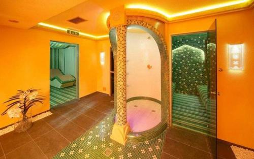 a room with a jacuzzi in a room with an orange wall at Apartmán PONIKLEC v hoteli Residence **** in Donovaly