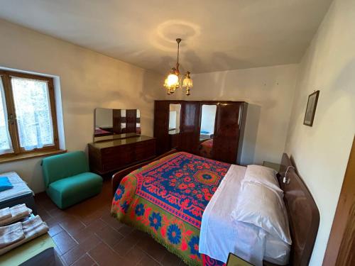 een slaapkamer met een bed en een groene stoel bij casa belvedere a Valle San Martino di Spoleto in Spoleto