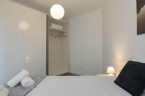 a bedroom with a white bed and a closet at Apartamento Carvajal in Málaga