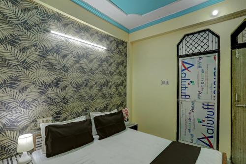 um quarto com uma cama e um mural de parede em OYO Flagship HOTEL RAJENDRA PALACE em Kanpur