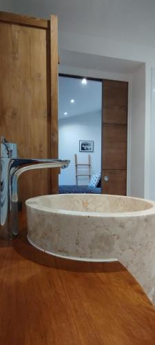 Cette chambre comprend une grande baignoire en pierre et un lavabo. dans l'établissement Claire & Co Chambre d'hôtes, à Pornic
