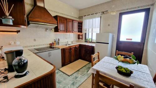 a kitchen with a table with a bowl of fruit on it at Villa Alta Vista in São Jorge