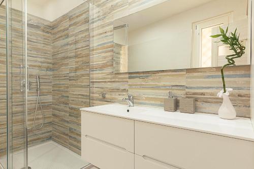 a bathroom with a sink and a glass shower at GLADIUS B&B in Santa Maria Capua Vetere