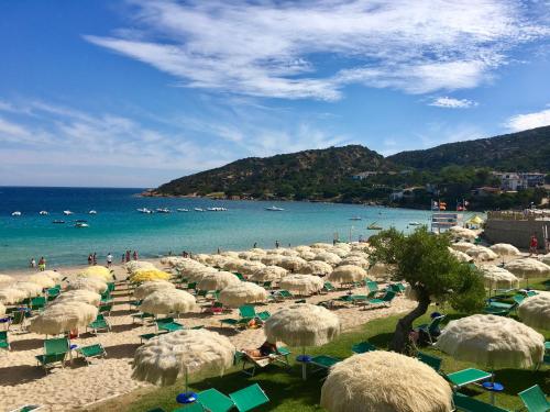 a beach with a bunch of umbrellas and the ocean at Seaside Apartment Baja Sardinia - 6pl August - 150 m from smeraldo beach in Baja Sardinia