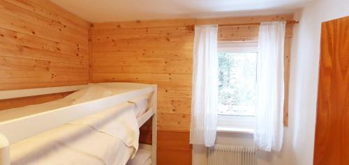 Cette petite chambre dispose d'une fenêtre et d'une baignoire. dans l'établissement Appartamento Pampeago 10, à Tesero