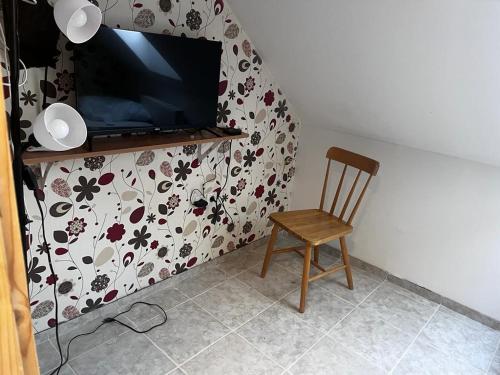 a chair in a room with a television on a wall at Minibar Inclusive! TH 326 City Center 40sqm Apartment in Szombathely