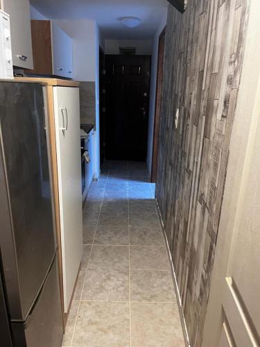 a hallway leading to a kitchen with a refrigerator at Minibar Inclusive! TH 326 City Center 40sqm Apartment in Szombathely