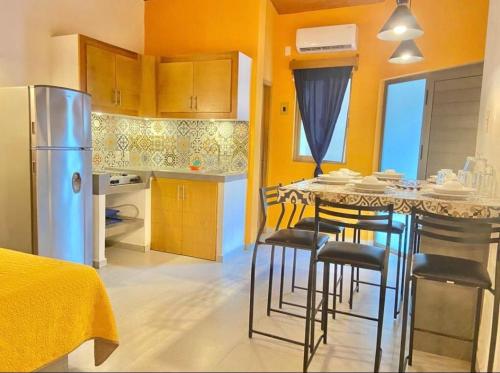 a kitchen with a table with chairs and a refrigerator at MarySol Las Palmas in Rincon de Guayabitos