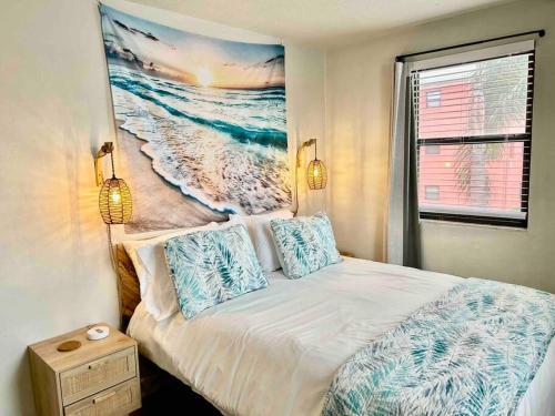 um quarto com uma cama com um quadro na parede em Ocean view balcony with heated pool em St. Pete Beach