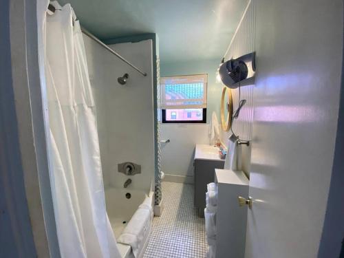 uma casa de banho com um chuveiro, uma banheira e um lavatório. em Ocean view balcony with heated pool em St. Pete Beach