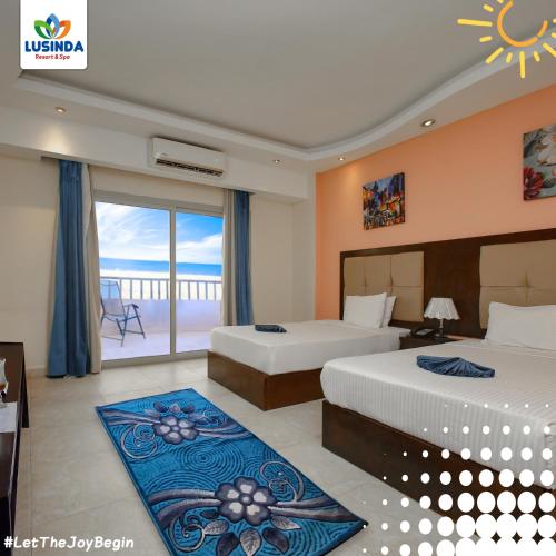 a hotel room with two beds and a balcony at LUSINDA HOTEL MANAGEMENT BY ZAD in Suez