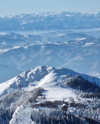 a snow covered mountain with a house on top of it at Vila Dizdarevic Kopaonik in Kopaonik
