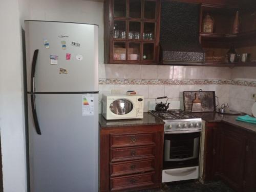 a kitchen with a white refrigerator and a microwave at Casa Grande in Las Grutas