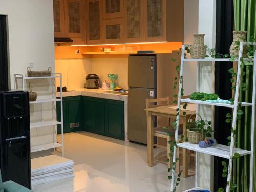 a kitchen with green cabinets and a black refrigerator at AdyneVille in Malang