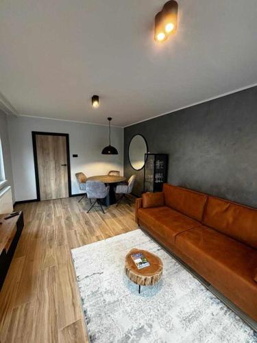 a living room with a couch and a table at HELLO Apartamenty - Pinia blisko Aquaparku in Karpacz
