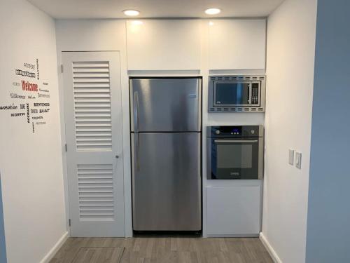 a kitchen with a stainless steel refrigerator and a microwave at Luxury Waterfront Villa 249C South Beach in Jolly Harbour