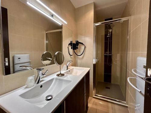 a bathroom with a sink and a shower at Logis Le Relais de la Voie Sacrée in Issoncourt