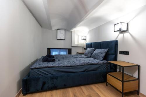 a bedroom with a large bed with a blue headboard at Downtown Elegance in Budapest