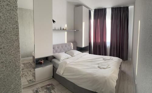 1 dormitorio con cama blanca y ventana en Lake&Forest, en Dudu