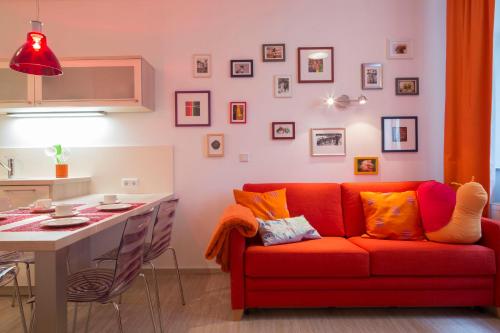 a living room with a red couch and a kitchen at Jovles Beisken GmbH in Münster