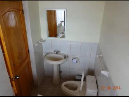 a small bathroom with a sink and a toilet at Hostal El Puerto in Yurimaguas