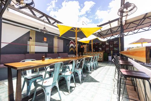 ein Restaurant mit Tischen, Stühlen und Sonnenschirmen in der Unterkunft Selina San Jose in San José