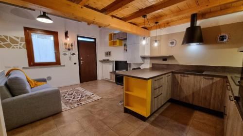 a kitchen with a counter and a couch in a room at Casa del Cedro - Comfort e relax in Legnano