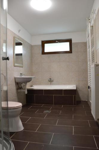 uma casa de banho com uma banheira, um WC e um lavatório. em Haus Im Zentrum L mit 2 Schlafzimmer und garten em Szombathely