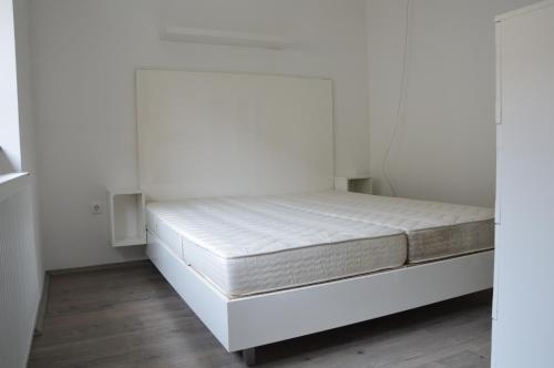 uma cama num quarto com paredes brancas em Haus Im Zentrum L mit 2 Schlafzimmer und garten em Szombathely