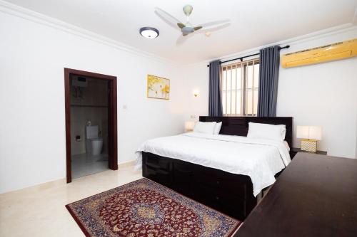 a bedroom with a large bed and a bathroom at Stay Play Away Residences - 3 bed, Airport Residential, Accra in Accra