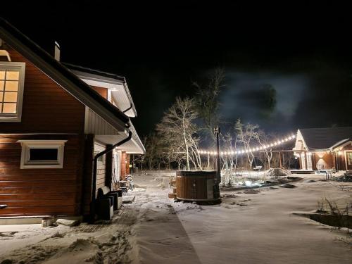 a night time picture of a house with snow and lights at Maja Matsalu luhal 
