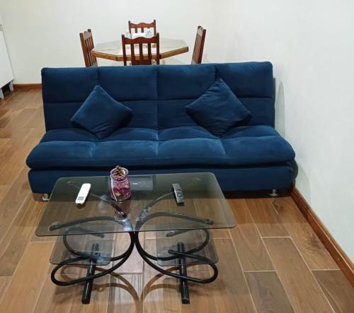 a blue couch sitting in a living room with a glass table at Departamento ELSA. La Crucecita, Huatulco. in Santa Cruz Huatulco