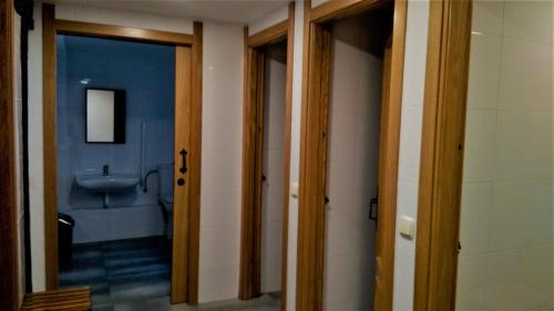 a bathroom with two doors and a sink and a toilet at Casa mandoia in Igorre