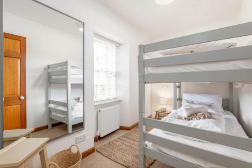 a bedroom with a bunk bed and a mirror at Crail Town House - Sleeps 6 in Crail