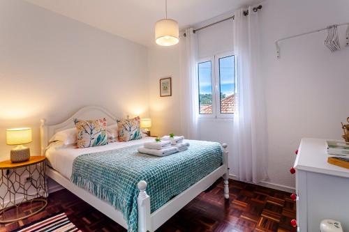 um quarto com uma cama e uma janela em A Casa da Tia em São Vicente