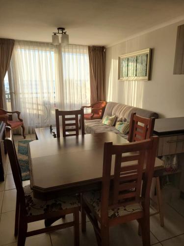 uma sala de estar com uma mesa e cadeiras e um sofá em Departamento la herradura frente al mar em Coquimbo