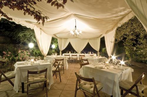 a marquee with tables and chairs in a garden at El Patio Hotel in Corciano