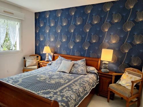 une chambre avec un lit et un mur bleu dans l'établissement Logement agréable proche Bordeaux, à Pont-de-la-Maye