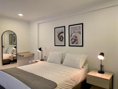 um quarto com uma cama, 2 candeeiros e um espelho em Lalinde by Wynwood House em Medellín