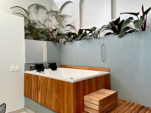 a bath tub in a room with plants at Lalinde by Wynwood House in Medellín