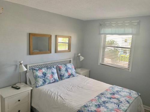 a bedroom with a bed and a window at Gorgeous Beach view balcony with heated pool in St Pete Beach