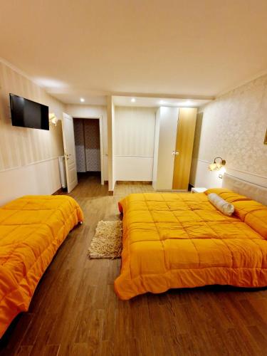 ナポリにあるFuga a Napoli Apartmentの黄色いシーツが敷かれたホテルの部屋にベッドが2つ