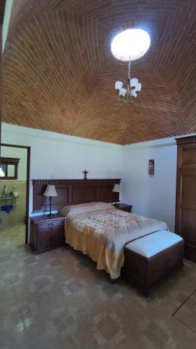 1 dormitorio con 1 cama grande y techo de madera en Casa rústica de campo, en Tecozautla