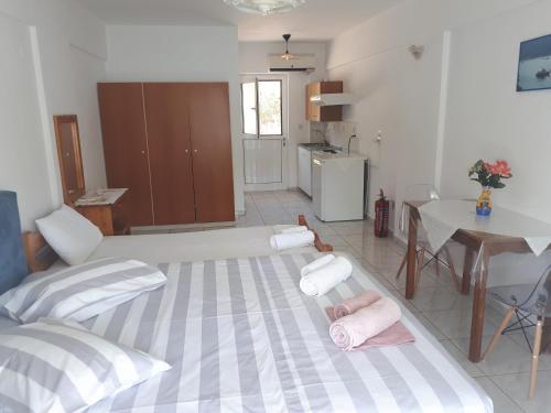 sala de estar con 2 camas, mesa y cocina en Geni Bay, en Yénion