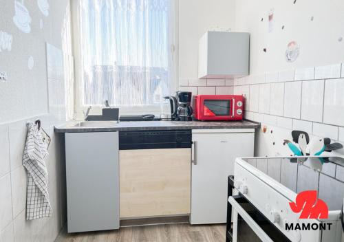 een keuken met een rode magnetron op een aanrecht bij Schöne, helle Monteurwohnung City-Nähe in Bremen