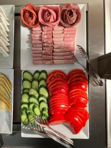 内亚卡瓦里Kavala Resort & Spa的一盘食物，上面有红色蔬菜和玫瑰花