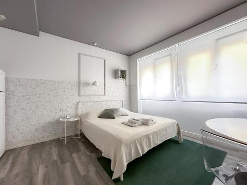 a white bedroom with a bed and a sink at Budget Inn in Valencia