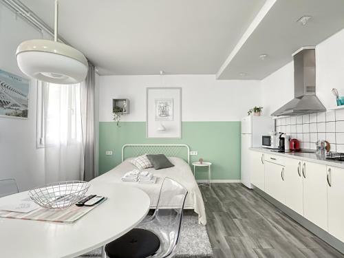 a white and green kitchen with a table in a room at Budget Inn in Valencia